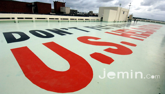 일본 오키나와현 기노와시 시청 옥상에 시청직원들이 주일미군(후텐마공군기지)항공기를 반대하는 문구를 적어놓고 있다.  <박민호 기자>