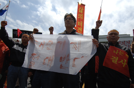 6일 해군기지건설 반대를 주장하는 위미리주민들이 항의시위가 열린 가운데 이 마을 청년회장이 혈서를 들고 반대 구호를 외치고 있다.   <박민호 기자>