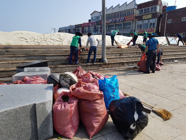 태풍 마이삭으로 탑동 광장 등에 밀려온 쓰레기를 지역 자생단체 회원들이 정리하고 있다.