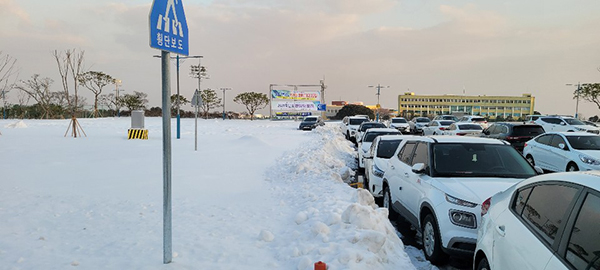 13일 오전 제주국제대학교 환승주차장에 많은 눈이 쌓였음에도 제설작업이 늦어져 도로변 불법 주·정차 현상이 연출됐다.