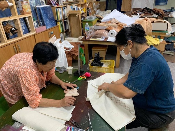 천연염색공예가 박지혜씨가 시어머니로부터 해녀복 만드는 법을 배우고 있다.