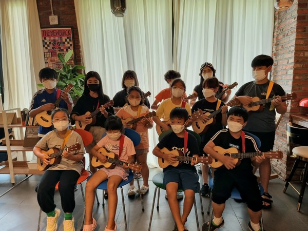 지난 18일 오후 제주시 구좌읍 해바라기지역아동센터 바로 앞에 위치한 서점 시타북빠에서 '코삭헌 노래 만들기' 프로그램에 참여한 아이들이 우쿨렐레를 연주하고 있다. 김재연 기자
