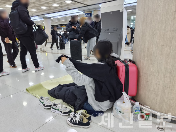 설 연휴 마지막 날인 24일 항공편이 전편 결항된 제주국제공항에 한 귀성객들이 돗자리를 펴고 대기표를 기다리고 있다. 김재연 기자