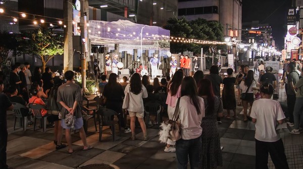 시민들과 관광객들이 누웨마루 야외무대서 공연을 관람하고 있다. 