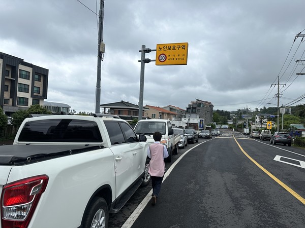 제주시내 노인보호구역 일대에 주·정차된 차량들이 줄지어 서 있으면서 보행자가 차도로 걷고 있다.