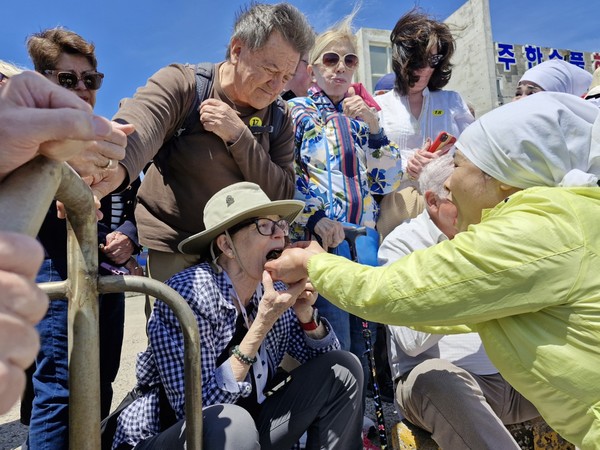한수풀해녀노래보존회가 17일 제주시 한림읍에 위치한 한수풀해녀학교 앞바다에서 물질 시연으로 채취한 해산물을 외국인 관광객에게 시식하도록 하고 있다. 김봉철 기자