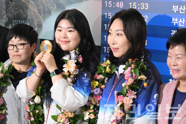 24일 파리올림픽 여자 공기권총 10m부문 금메달리스트 오예진(기업은행, 사진 왼쪽 두 번째)이 제주국제공항에서 어머니인 송미순씨와 스승 홍영옥 국가대표 코치, 김애숙 도 정무부지사 등과 기념촬영을 하고 있다. 김은수 기자