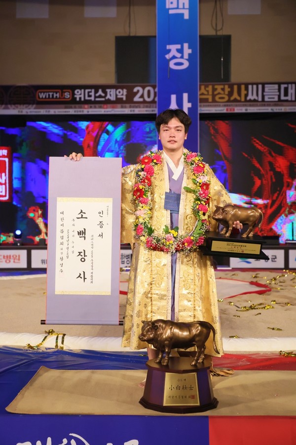 실업 데뷔 6년 만에 소백장사에 등극한 황찬섭이 생애 첫 황소 트로피를 들어올리며 기념촬영을 하고 있다.