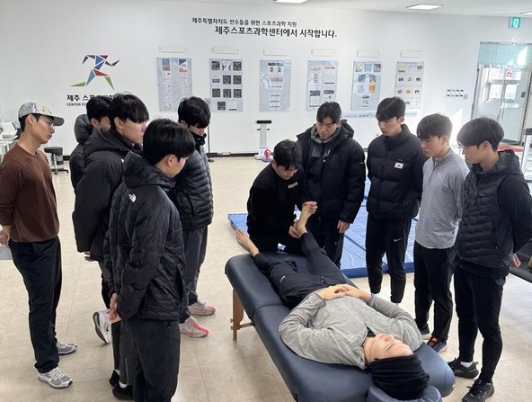 제주스포츠과학센터 소속 김홍현 회복운동트레이너가 한국체대 육상선수들에게 아킬레스건 마사지를 시연하고 있다.