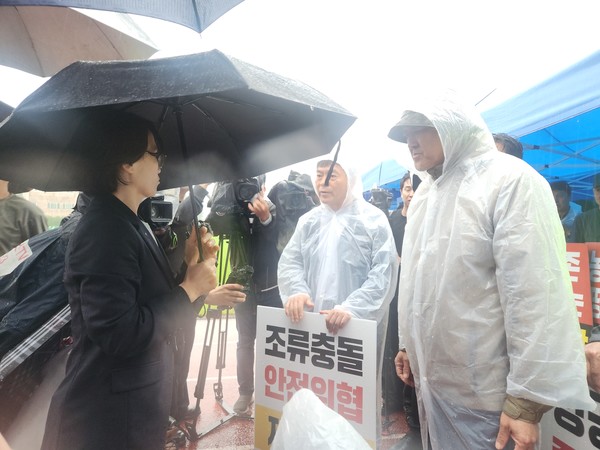 지난 16일 성산읍국민체육센터 운동장에 마련된 제2공항 환경영향평가협의회 회의장 앞에서 고선애 환경정책과장(사진 왼쪽)과 반대단체 대표들이 대치하고 있다. 윤승빈 기자