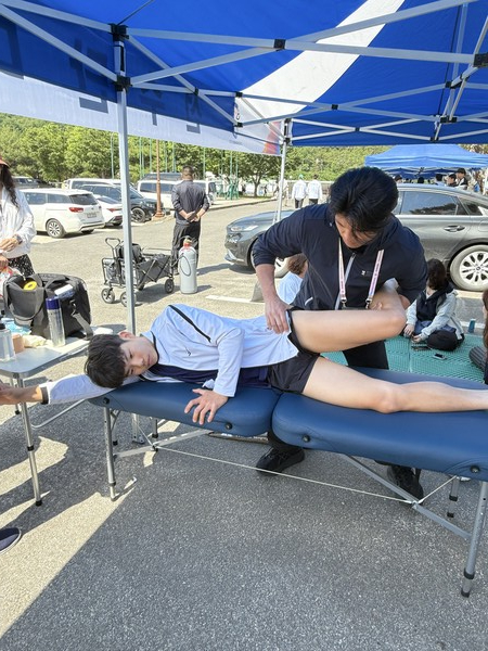 제주스포츠과학센터 트레이너가 근대3종 경기에 출전한 귀일중 신현규에게 다리 근육이완 마사지를 실시하고 있다.