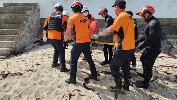 지난 10일 제주시 구좌읍 한동리 해안가에서 발견된 시신을 119 구조대가 수습하고 있다.